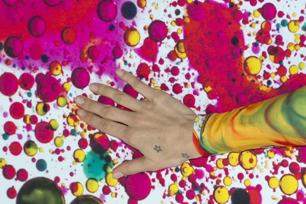 Female hand on colour wall — Stock Photo, Image