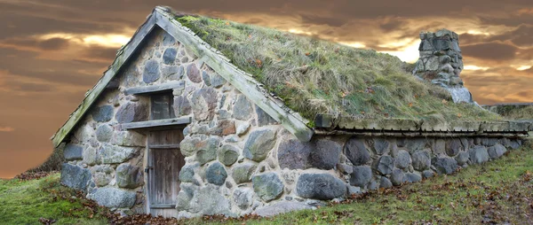 Kamienna chata z trawą na dachu — Zdjęcie stockowe