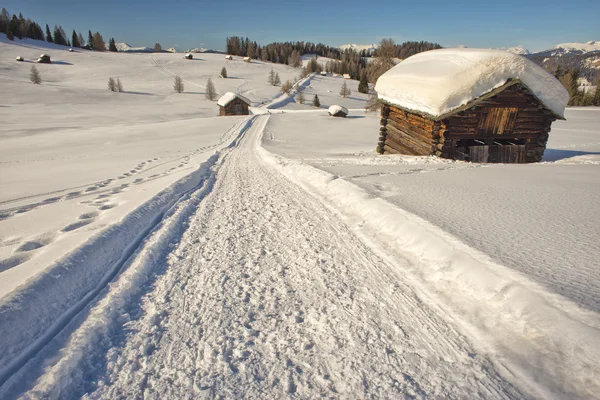 Una cabaña de madera en el fondo de nieve de invierno — Foto de Stock
