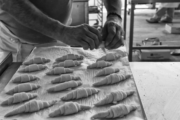 Hands preparing french croissant in black and white — Stock Photo, Image