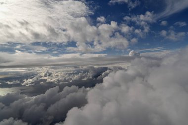Uçaktaki yolcu penceresinden bulutlu gökyüzü