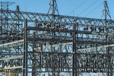 Metal direklerdeki yüksek voltajlı elektrik kabloları detaylandırılmış.