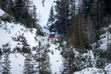 red on white snow snowmobile going up fanes mountain in dolomites