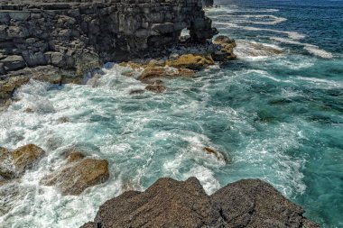 Pico Adası lav kayalıklarında dalgalanır.