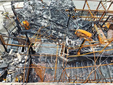 Yanan metal yapılar, deniz kıyısında yangın üstüne yangın.