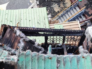 Yanan metal yapılar, deniz kıyısında yangın üstüne yangın.