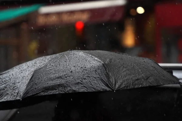 open black umbrella under heavy rain in chinatown new york city manhattan