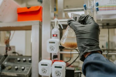 Bilimadamı çözümler hazırlıyor ve laboratuarında kimyasal reaksiyonların sonuçlarını analiz ediyor..