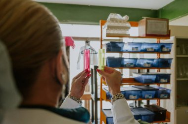 Bilimadamı çözümler hazırlıyor ve laboratuarında kimyasal reaksiyonların sonuçlarını analiz ediyor..