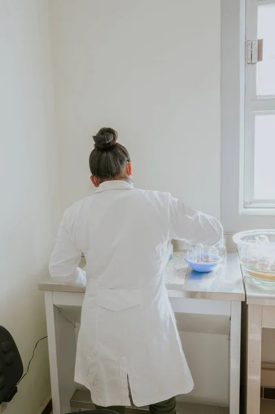 Bilimadamı çözümler hazırlıyor ve laboratuarında kimyasal reaksiyonların sonuçlarını analiz ediyor..