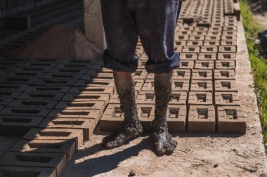 Bir tuğla işçisinin çamurlu ayakları..