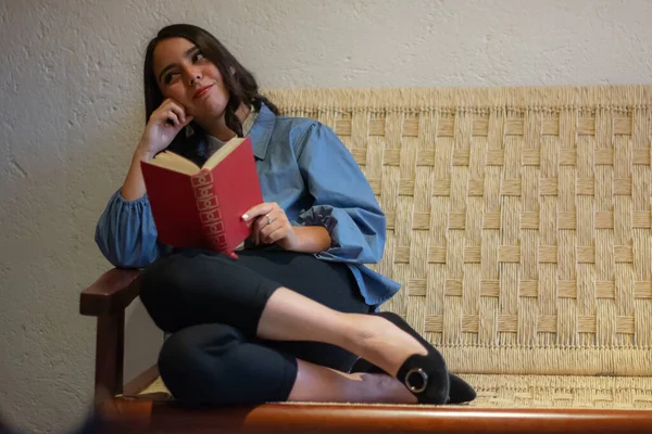 Молодая Латиноамериканка Читающая Книгу Сидя Крыльце Своего Дома Отдыхает Плетеном — стоковое фото