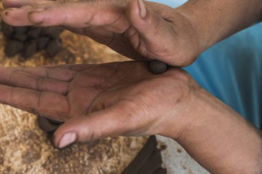 Bir balığın kil figürünü yapan zanaatkârın elleri, pulları gibi detaylar yaratarak, malzemeyi nasıl idare ettiğini görmemizi sağlıyor..