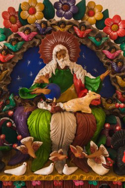 Yaradan 'ın kil figürü, kucağında bir kuzuyla..