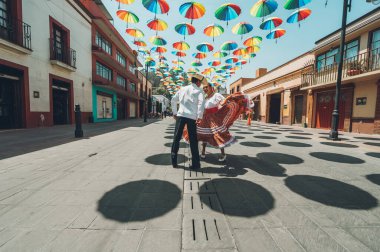Meksika 'nın orta kesimindeki tipik Meksika dansçıları gösterilerini renkli şemsiyelerle süsleyip sokakta yapıyorlar..