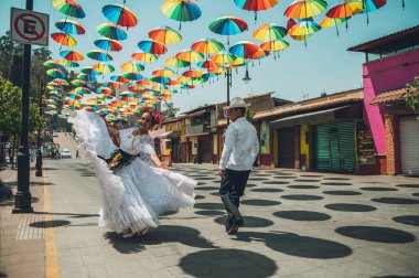 Meksika 'nın Veracruz bölgesinden tipik Meksikalı dansçılar, gösterilerini renkli şemsiyelerle süsleyip sokakta yapıyorlar..