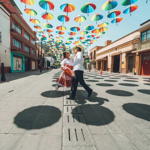 Meksika 'nın orta kesimindeki tipik Meksika dansçıları gösterilerini renkli şemsiyelerle süsleyip sokakta yapıyorlar..