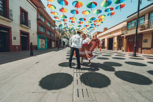 Meksika 'nın orta kesimindeki tipik Meksika dansçıları gösterilerini renkli şemsiyelerle süsleyip sokakta yapıyorlar..