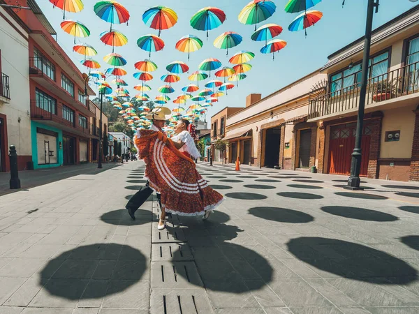 Meksika 'nın orta kesimindeki tipik Meksika dansçıları gösterilerini renkli şemsiyelerle süsleyip sokakta yapıyorlar..