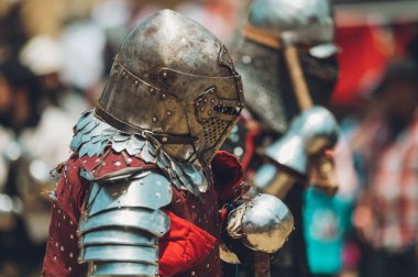 Pitch battle of medieval knights, using metal armor, axes, swords and shields to defend themselves.
