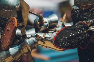 Ortaçağ şövalyelerinin çarpışması. Kendilerini savunmak için metal zırhlar, baltalar, kılıçlar ve kalkanlar kullanıyorlar..