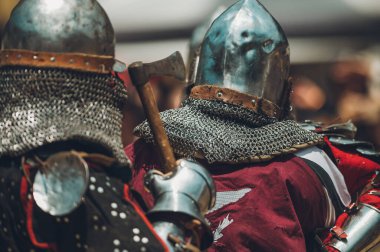 Pitch battle of medieval knights, using metal armor, axes, swords and shields to defend themselves.