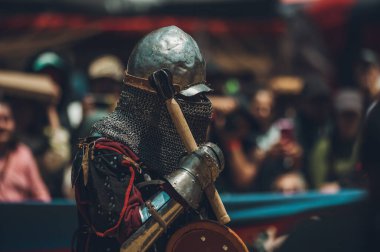 Ortaçağ şövalyelerinin çarpışması. Kendilerini savunmak için metal zırhlar, baltalar, kılıçlar ve kalkanlar kullanıyorlar..