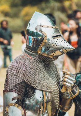 Ortaçağ şövalyelerinin çarpışması. Kendilerini savunmak için metal zırhlar, baltalar, kılıçlar ve kalkanlar kullanıyorlar..