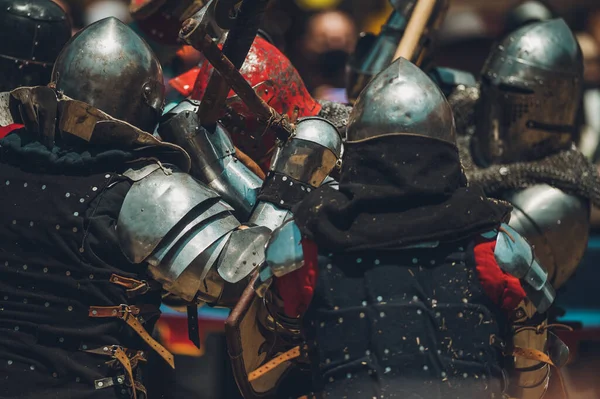 Ortaçağ şövalyelerinin çarpışması. Kendilerini savunmak için metal zırhlar, baltalar, kılıçlar ve kalkanlar kullanıyorlar..