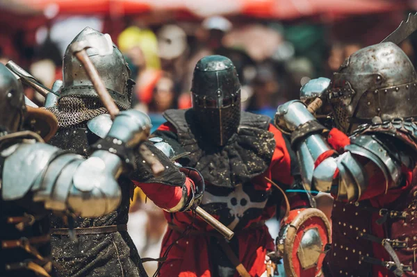 Ortaçağ şövalyelerinin çarpışması. Kendilerini savunmak için metal zırhlar, baltalar, kılıçlar ve kalkanlar kullanıyorlar..