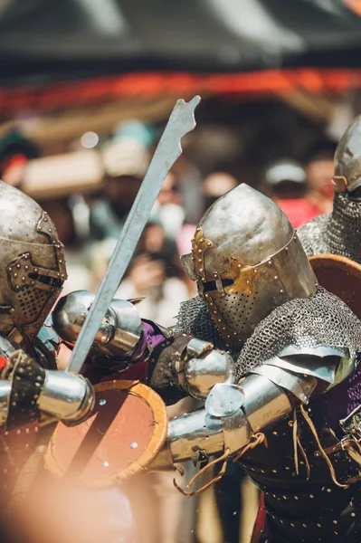 Ortaçağ şövalyelerinin çarpışması. Kendilerini savunmak için metal zırhlar, baltalar, kılıçlar ve kalkanlar kullanıyorlar..