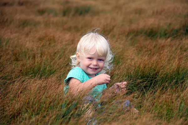 Barn girl spela på ängen — Stockfoto