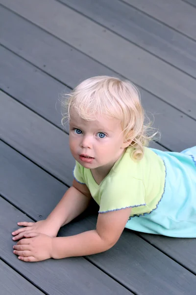 Döşeme gri renk zeminde yürümeye başlayan çocuk kız — Stok fotoğraf