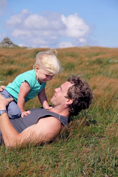 Pai e filha no prado de grama — Fotografia de Stock