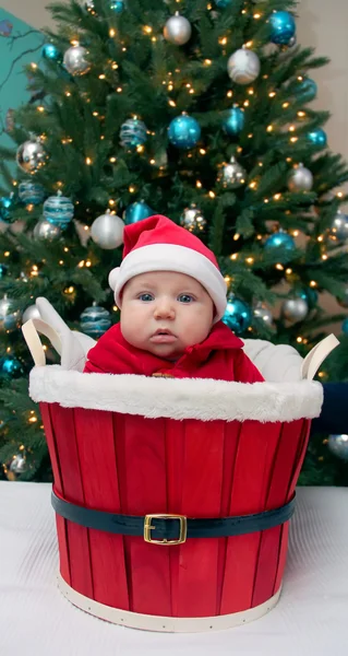 Pojke i santa hatt i röda korgen — Stockfoto