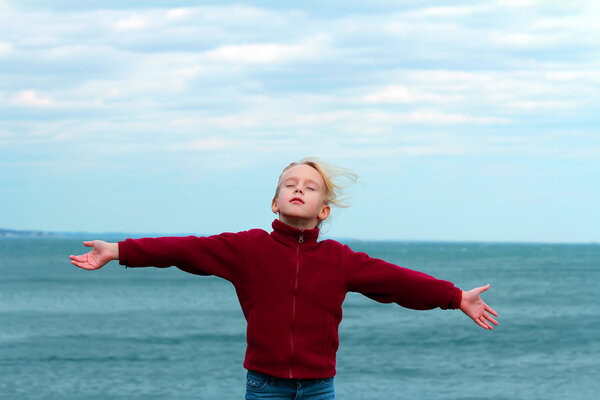 Подростковые руки девушки, поднятые, наслаждаясь свежим океанским воздухом
.