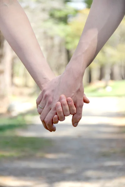 Paar hält Händchen in einem Park — Stockfoto