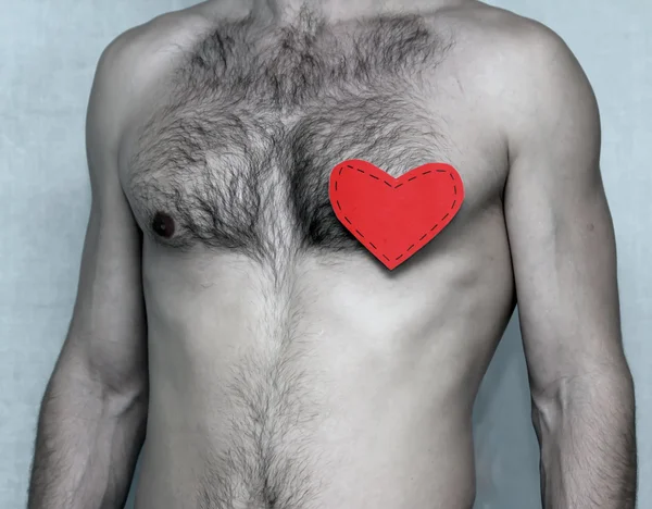 O peito do homem com um coração vermelho — Fotografia de Stock