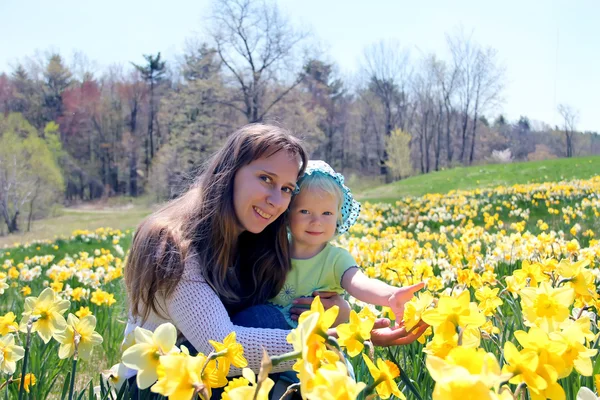 Mother with her daughter in daffodil field — Stock Photo, Image