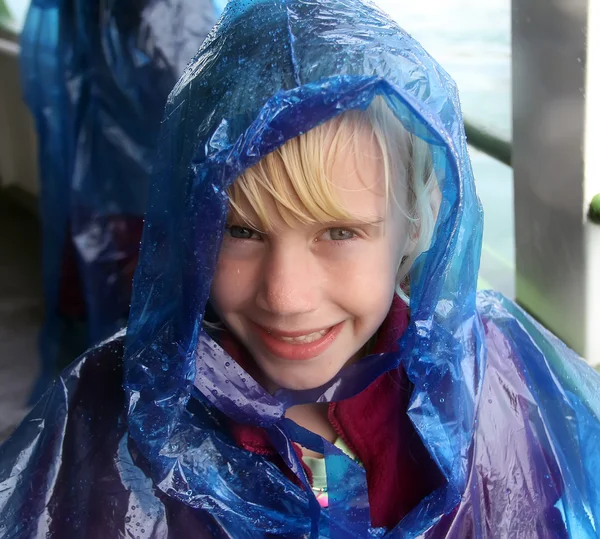 Happy little girl in blue raincoat