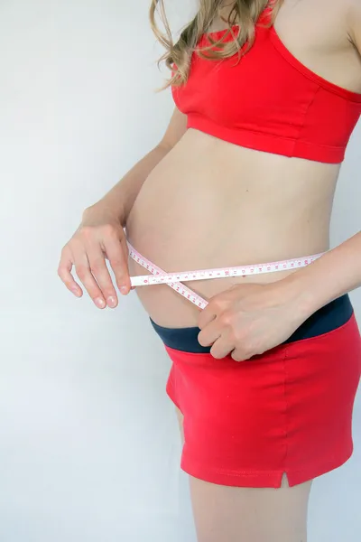 Pregnant woman measures the belly — Stock Photo, Image