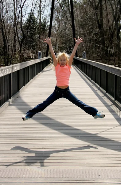 Girl jumping on the bridge — Stock Photo, Image