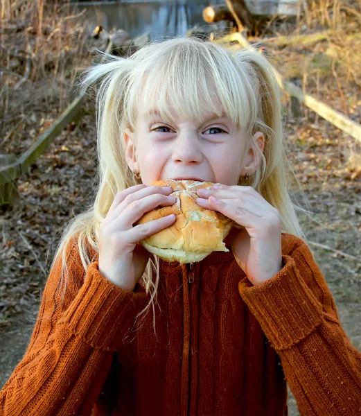 Menina mordendo o pão simples — Fotografia de Stock