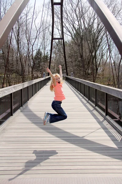 Girl jumping on the bridge — Stock Photo, Image