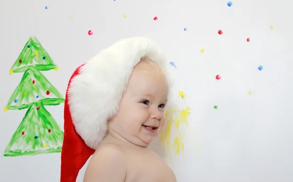 Usmíval se roztomilé batole v santa hat — Stock fotografie