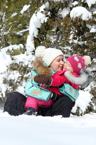 Feliz madre jugando con su hija pequeña en el parque de invierno —  Fotos de Stock