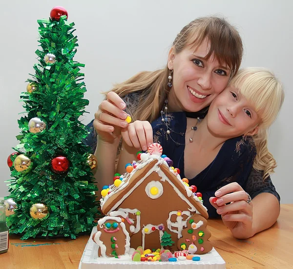 Gelukkig moeder en dochter zijn peperkoek huis verfraaien — Stockfoto