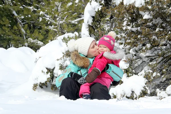 Szczęśliwą matką, grając z córką malucha w winter park — Zdjęcie stockowe