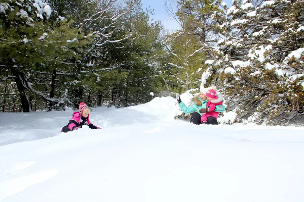 Happy mother and her daughters playing in the winter park — Stock Photo, Image