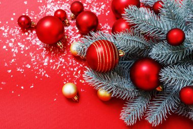 Kırmızı ve yeşil renklerde bir Noel arkaplanı. Noel ağacı, büyük ve küçük kırmızı toplar, altın bokeh. Yatay olarak. Mesaj için yer. Mutlu yıllar, kış konsepti. Kimse.